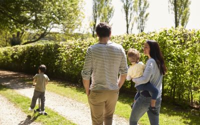 Rear View Of Family Going For Walk In Summer Countryside